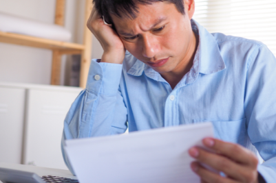 Puzzled worker struggling to understand confusing workers' compensation paperwork